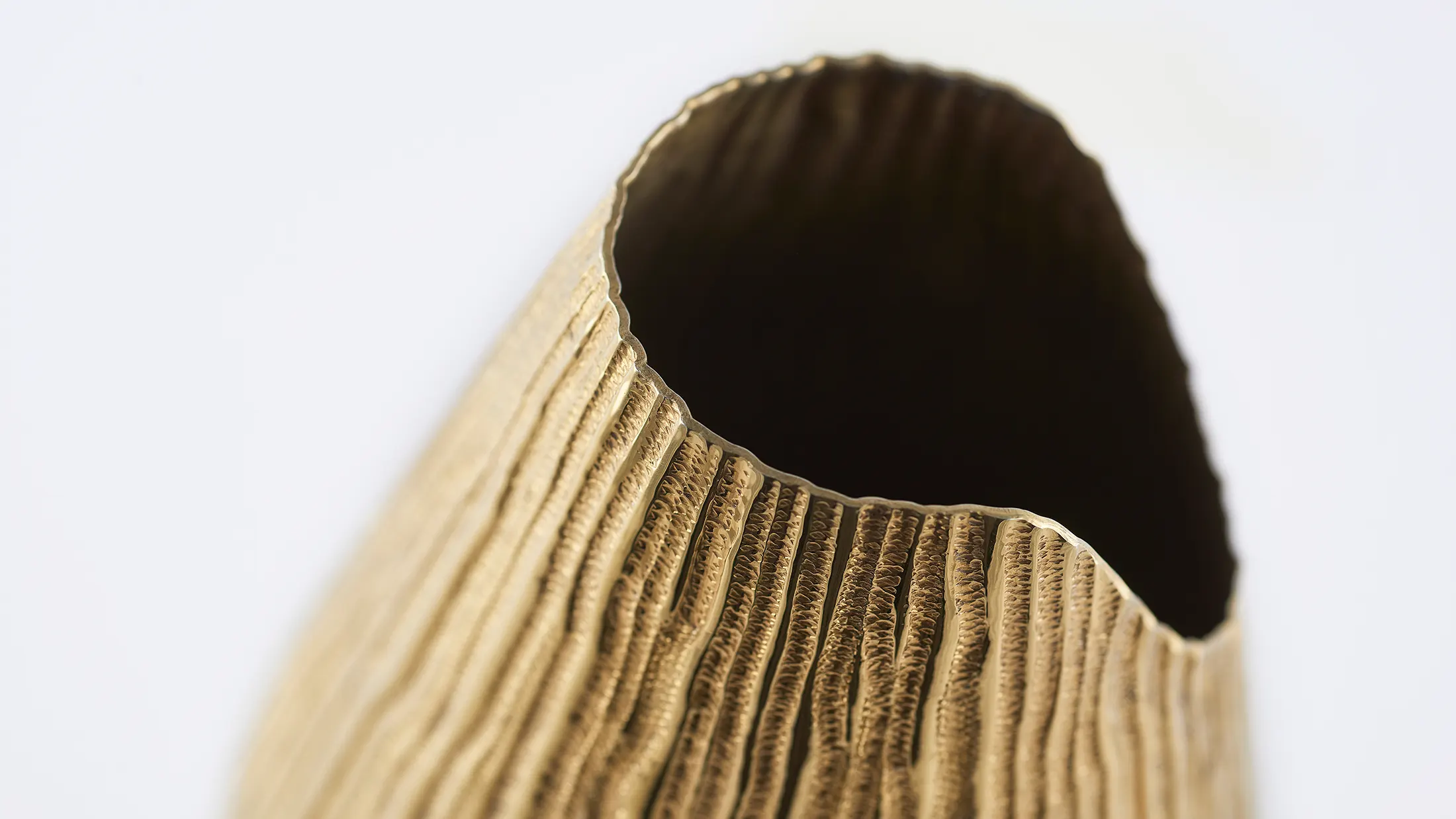 Studio still life photograph of a gold bottle cover by K-Over on a white background – product photography by Memento Agency