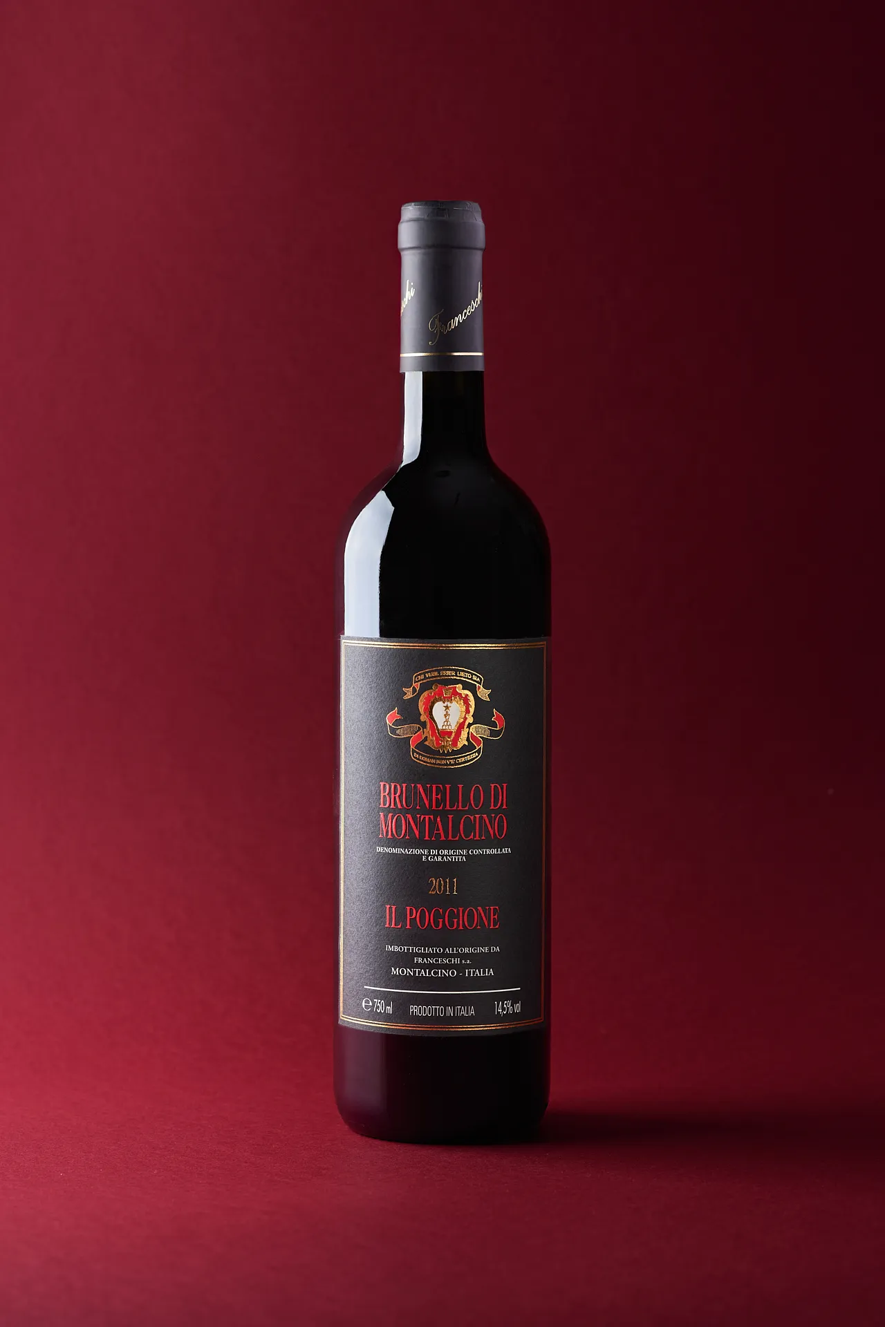 Still life photo of Brunello di Montalcino wine bottle from Il Poggione on red background – elegant Tuscan wine product photography