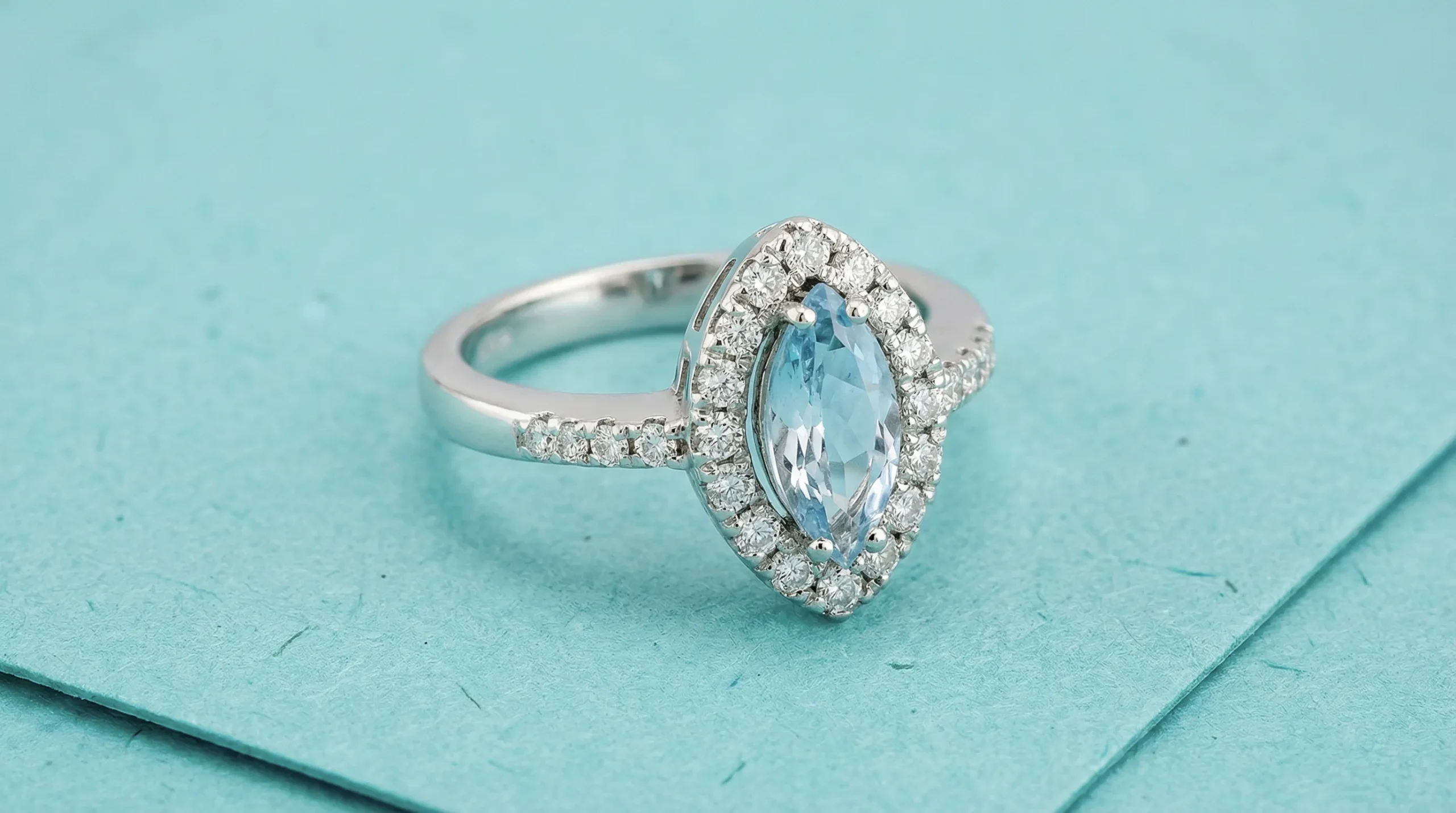 Ambient still life photo of Gioielleria Italiana aquamarine and diamond ring on blue background, handcrafted jewelry