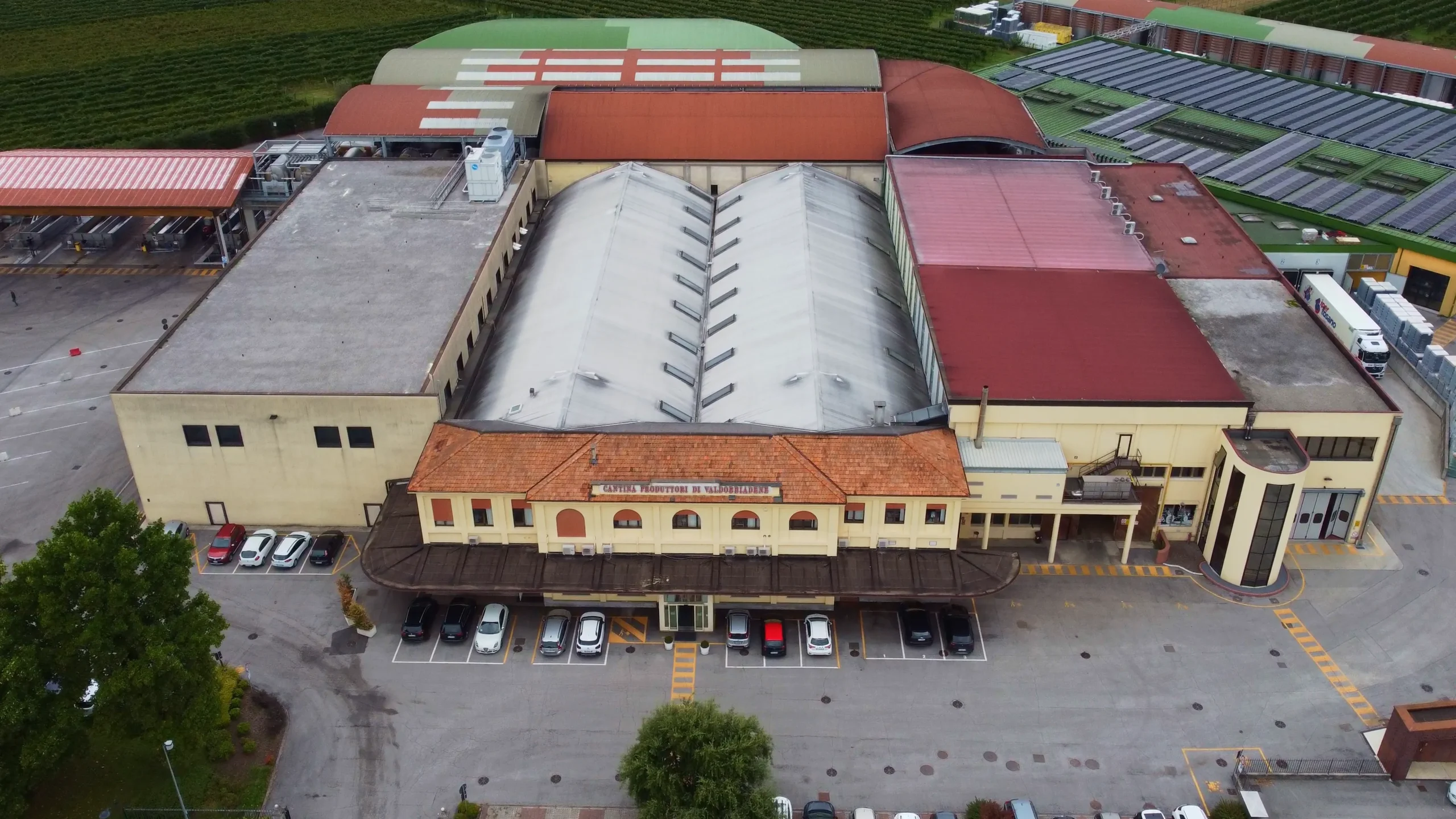 Drone video frame showing an aerial view of Val d'Oca facilities, captured for Kiwitron by Memento Agency – promotional aerial footage of the winery
