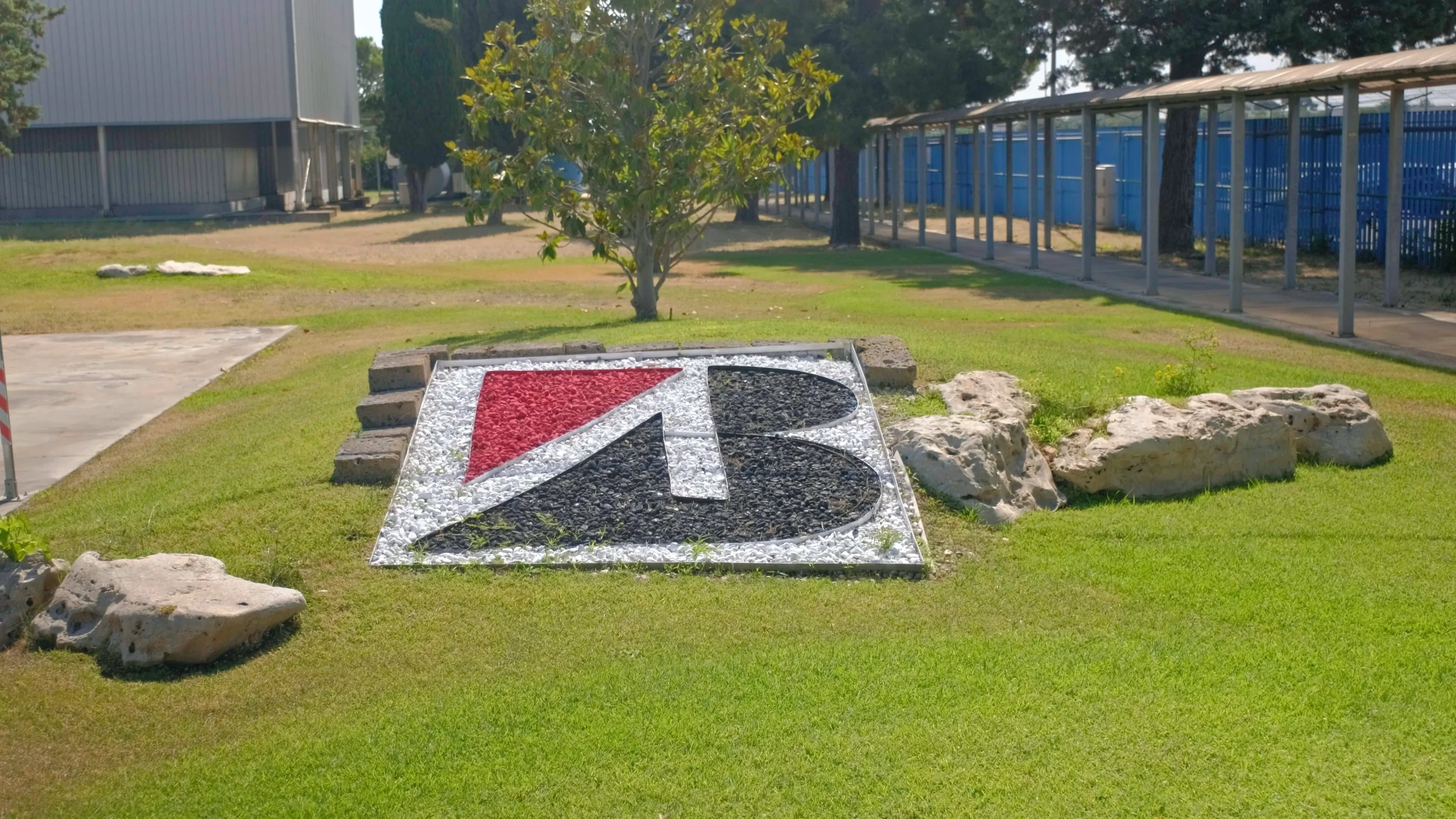 Video frame of the Bridgestone logo in the company garden at the Bridgestone Italia facility, captured for Kiwitron by Memento Agency – industrial promotional footage
